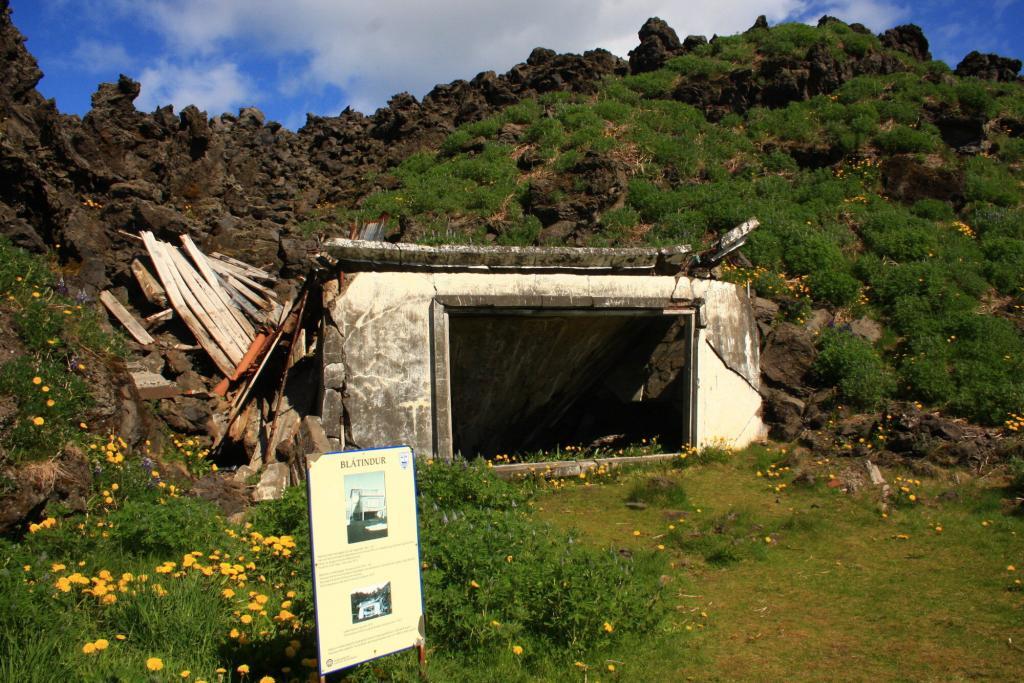 Ruins of a house underneath a heavy load of ash and pumice.