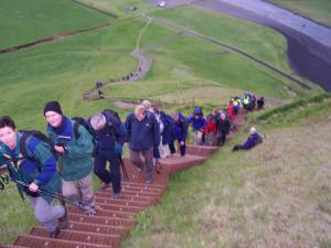 Optimistic hikers going up the bridge at the Skógar waterfall on the starting point for the Fimmvörðuháls hike. Little did they know.