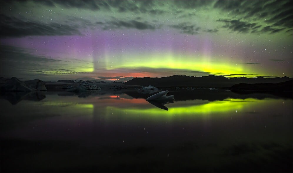 Glow from the volcanic eruption in Holuhraun is reflected in the Jokulsarlon glacial lagoon and in the heavens