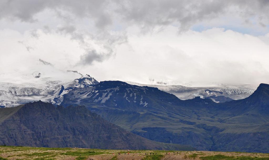 A group of hikers enjoy the vast sweeping views of the beautiful highland nature.