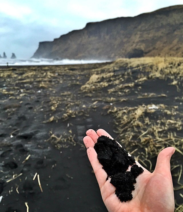 Black sand makes the beach black.