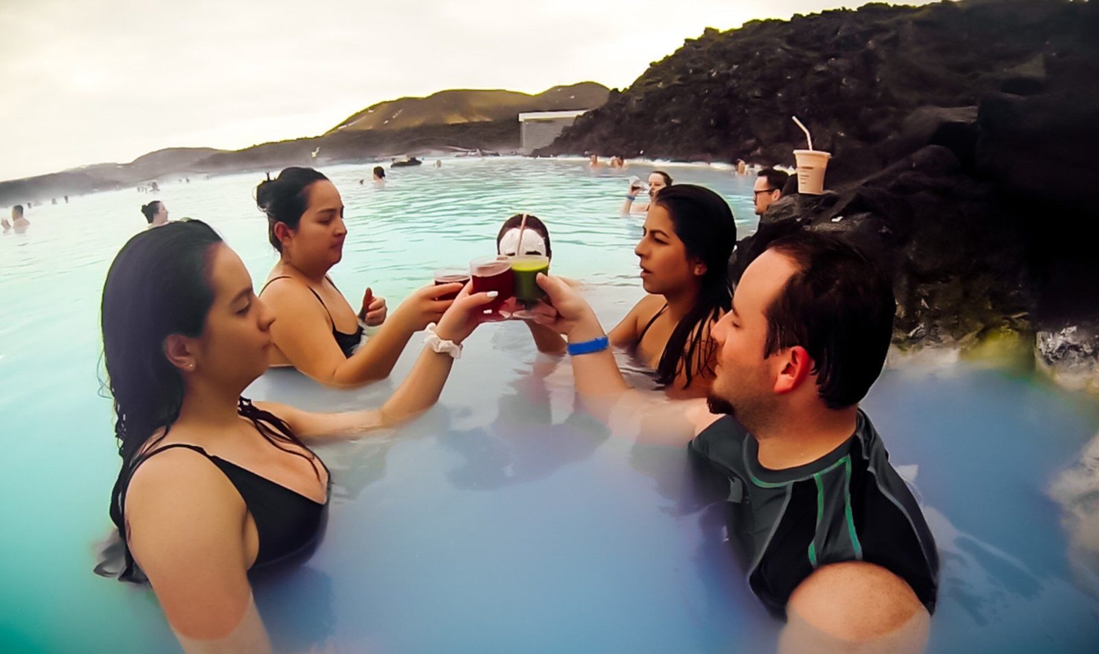 Four people having a drink in the Blue Lagoon in Iceland in winter.