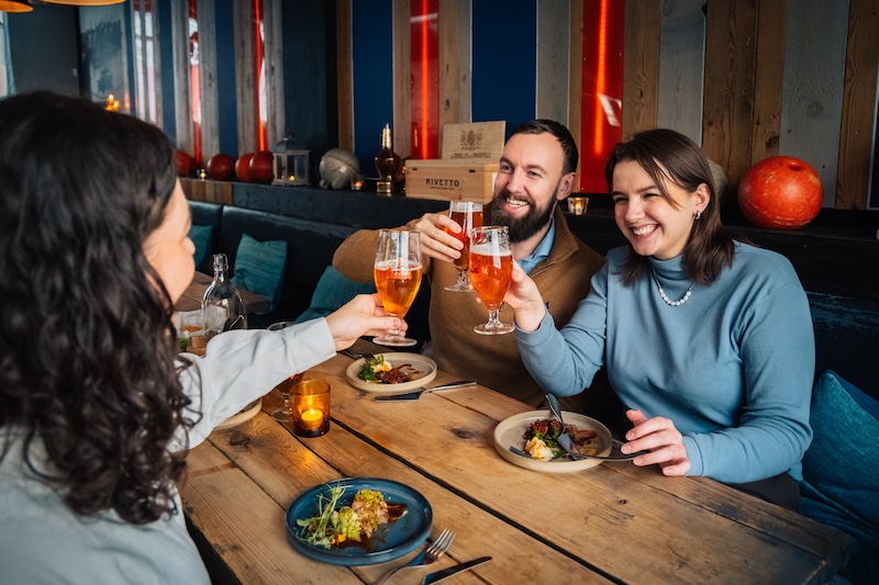 People raise their glasses of beer at a restaurant in Reykjavik, Iceland.