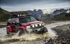 A truck from Midgard tackles a river in the Icelandic highlands.