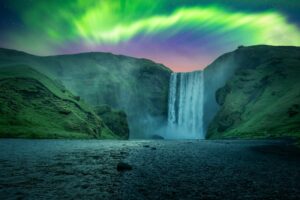 The northern shimmer above Skógafoss in Iceland.