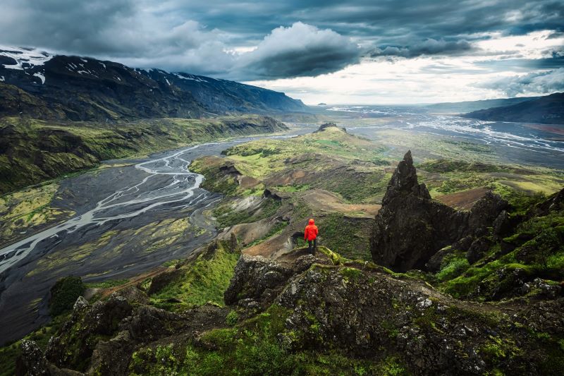 A man enjoys the stunning view on the top of Mt. Valahnjukur at Thorsmork in Iceland. 